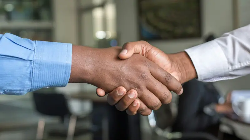 Aperto de mão entre duas pessoas