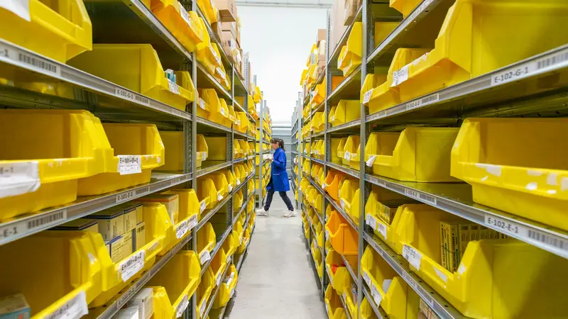 Corredor de separação de pedidos com caixas amarelas nas estantes